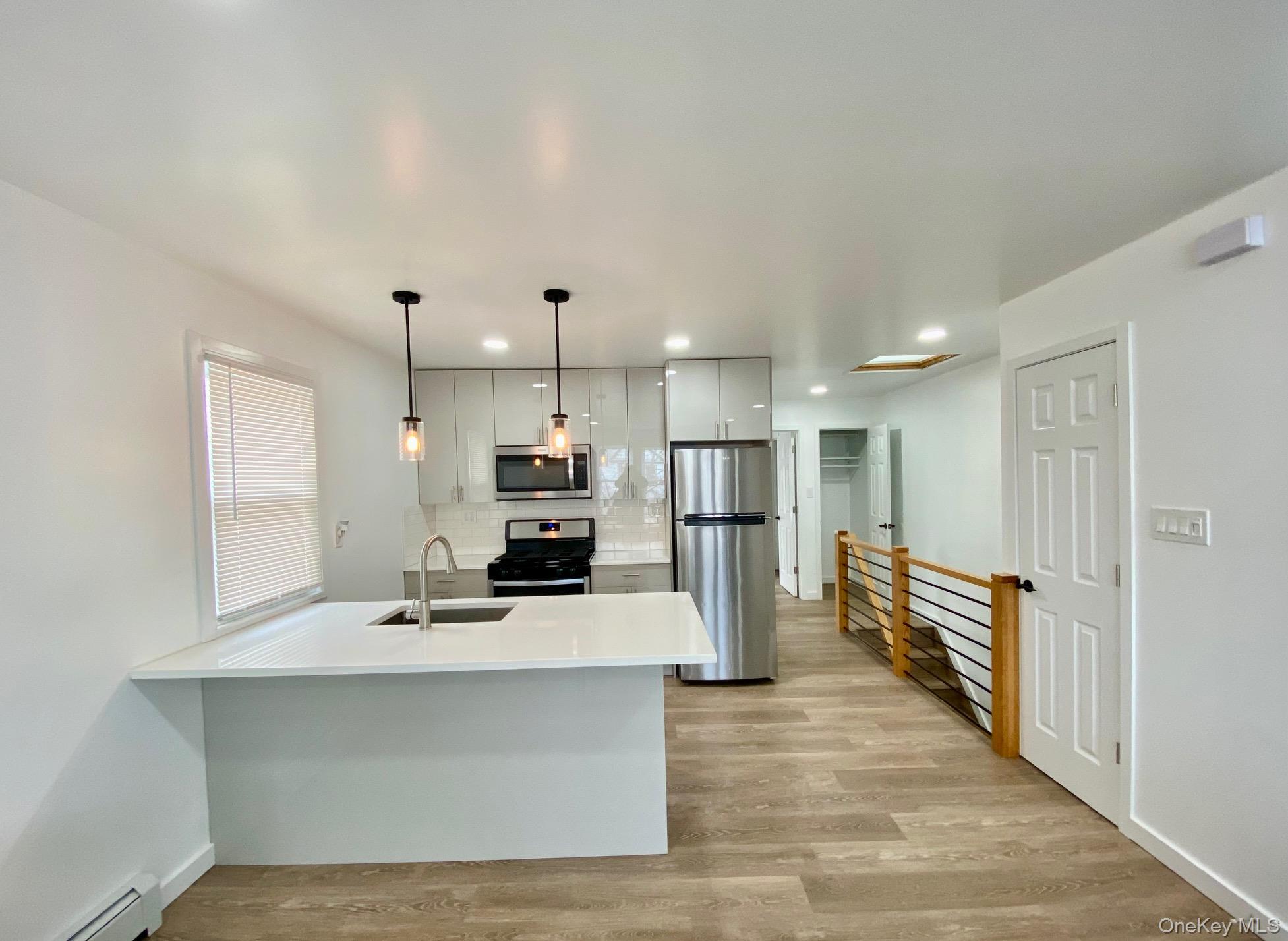 a large white kitchen with lots of counter top space and refrigerator