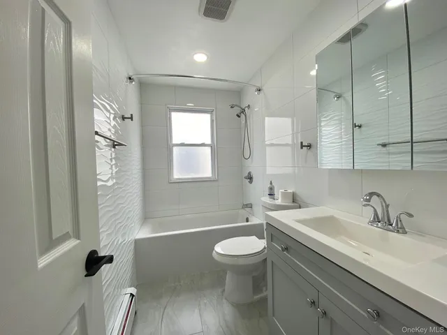 a large white kitchen with lots of counter top space and refrigerator