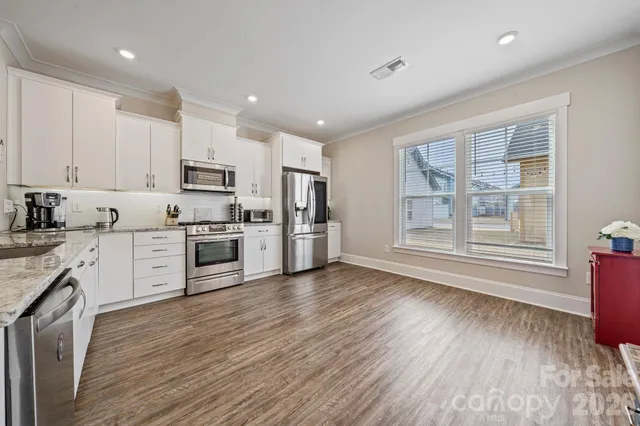 a kitchen with stove cabinets and wooden floor