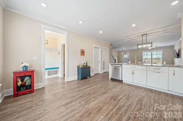 a large white kitchen with wooden floors and stainless steel appliances