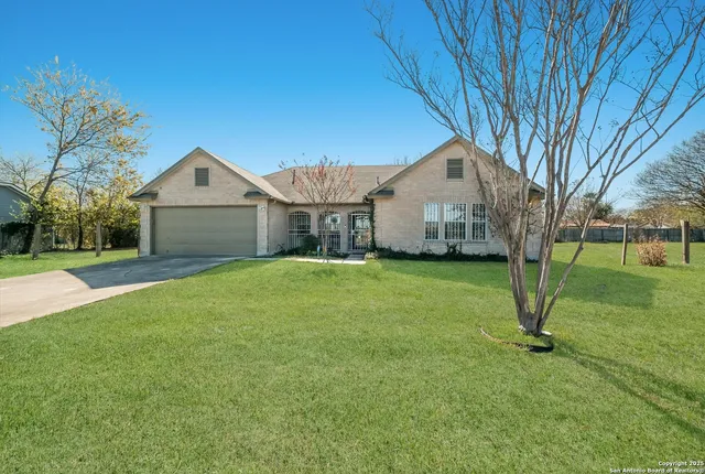 a front view of a house with a garden and trees