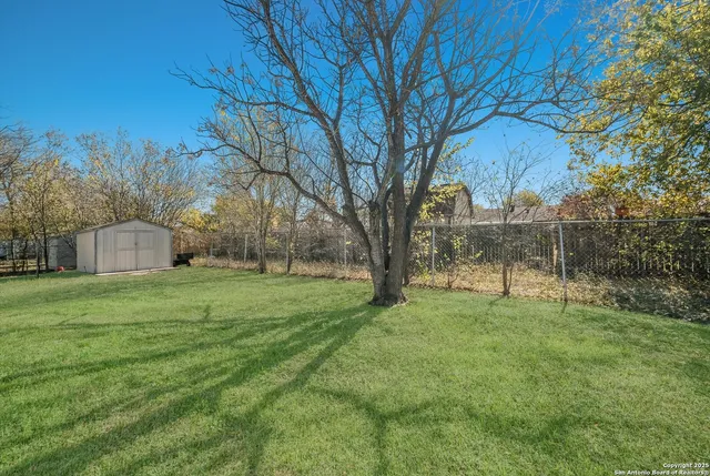 a view of a backyard with large trees