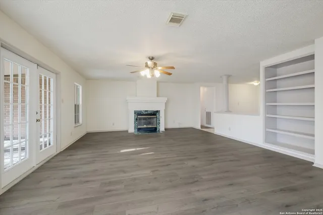 a view of an empty room with a fireplace and a window