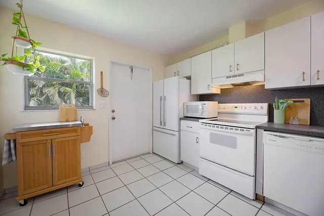 a kitchen with white cabinets and white appliances