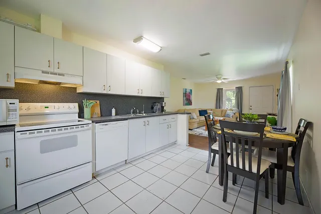 a kitchen with white cabinets and white appliances