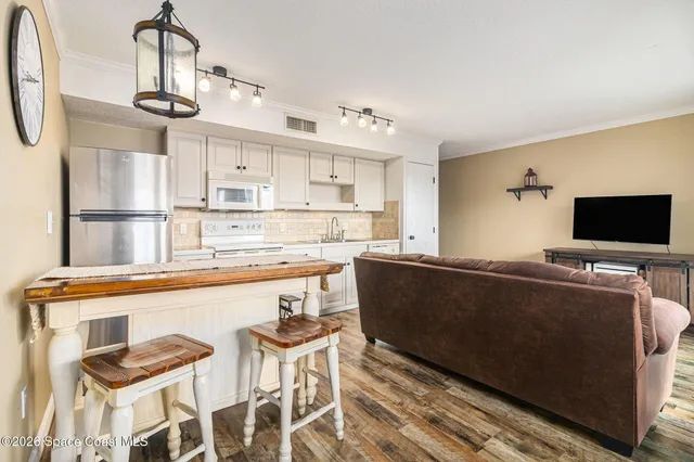 a living room with stainless steel appliances kitchen island granite countertop furniture and a kitchen view