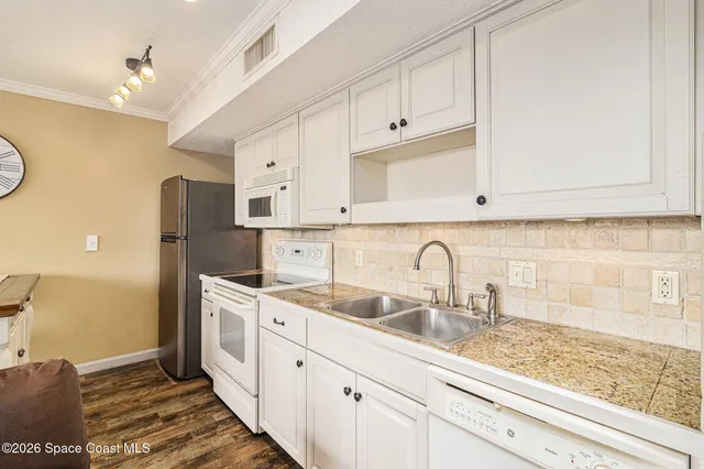a kitchen with stainless steel appliances granite countertop a sink a stove and a refrigerator