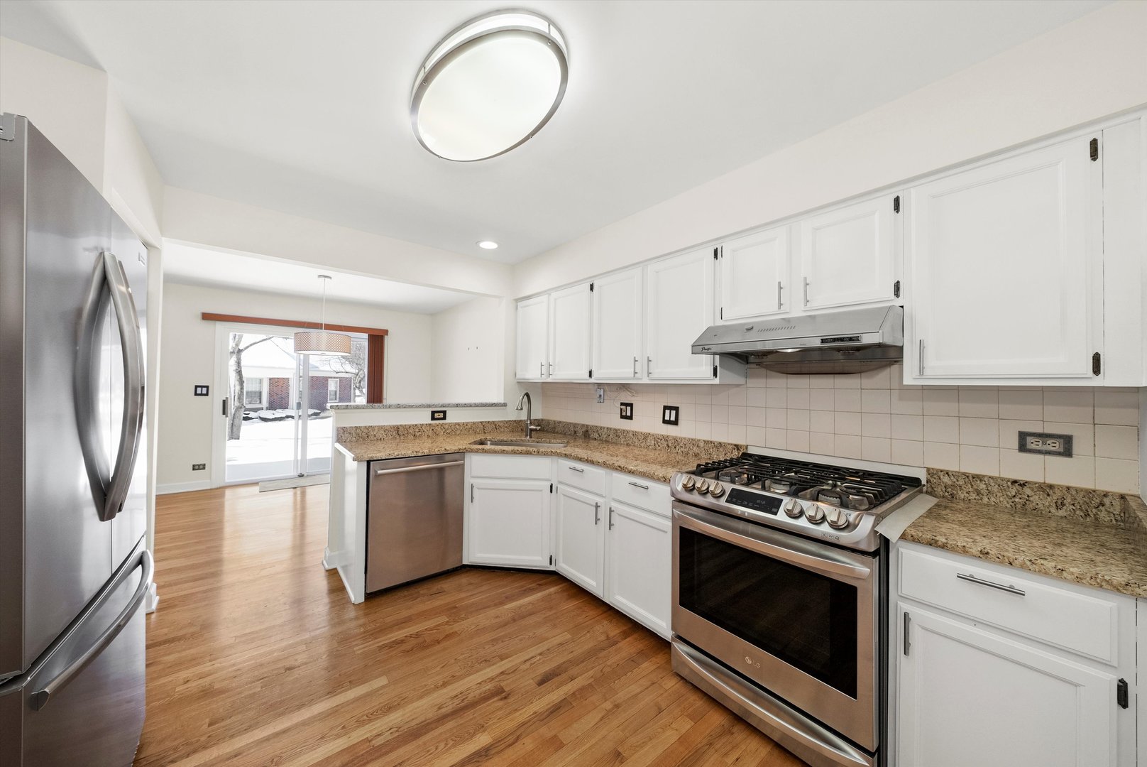 289 Ripplebrook Court Schaumburg, IL 60173 - Photo 12 of 31 a kitchen with stainless steel appliances granite countertop a stove top oven a sink dishwasher and a refrigerator with wooden floors