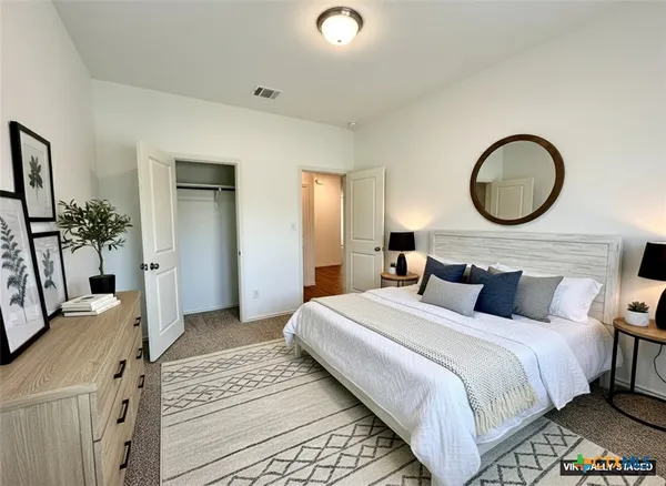 a bedroom with a large bed and a chandelier