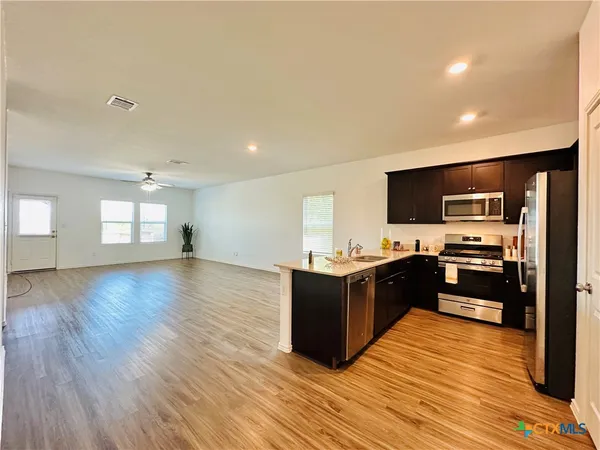 a large kitchen with kitchen island granite countertop a stove top oven and refrigerator
