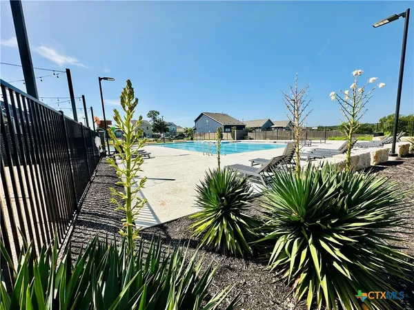 a swimming pool with outdoor seating and plants
