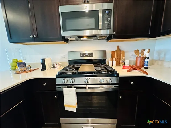 a kitchen with stainless steel appliances granite countertop a stove and a microwave