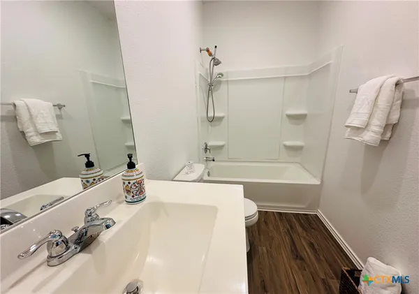 a bathroom with a tub sink and mirror