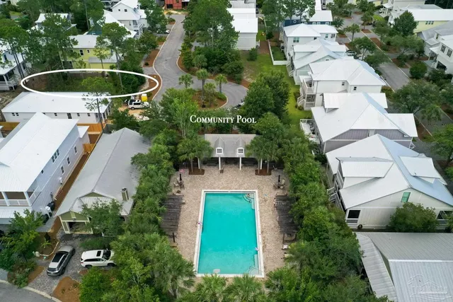 an aerial view of a house with swimming pool and outdoor seating