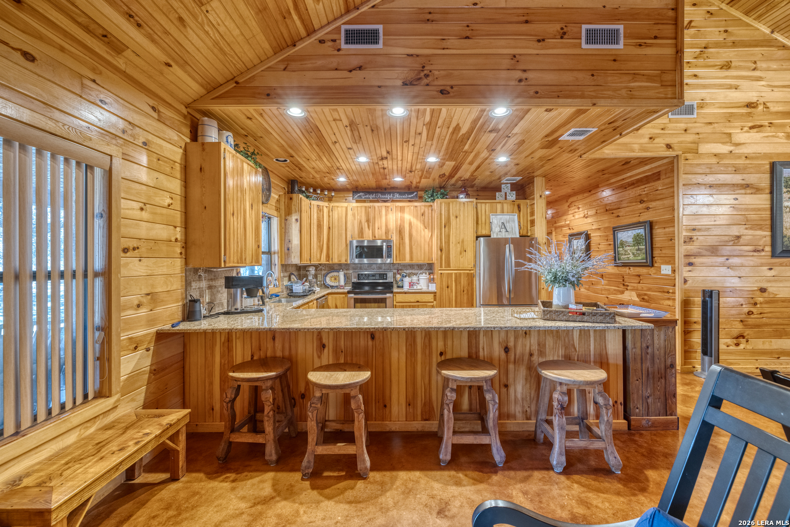 206 South River Pl Road Rio Frio, TX 78879 - Photo 6 of 14 a dining hall with stainless steel appliances kitchen island granite countertop a table chairs and a large window