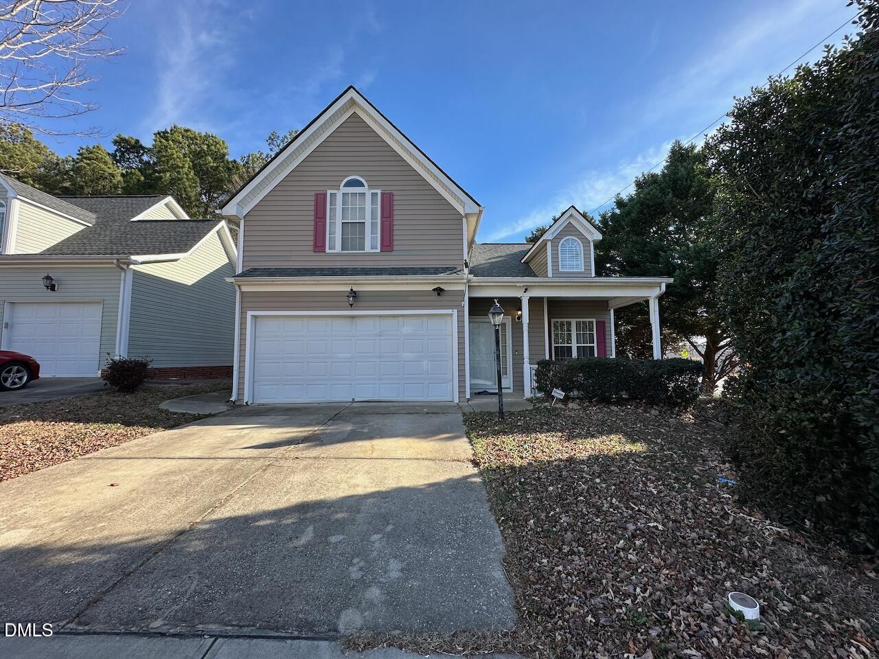 a view of a yard in front of a house with large windows