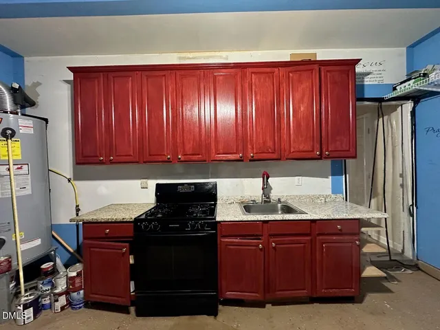 a kitchen with granite countertop wooden cabinets and a stove top oven