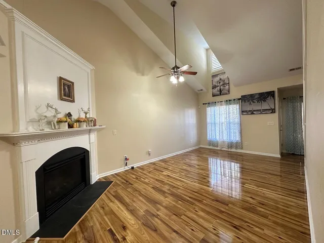 a view of empty room with fireplace and wooden floor