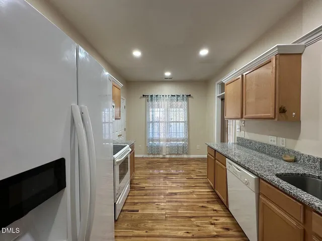a kitchen with stainless steel appliances granite countertop a refrigerator and a sink
