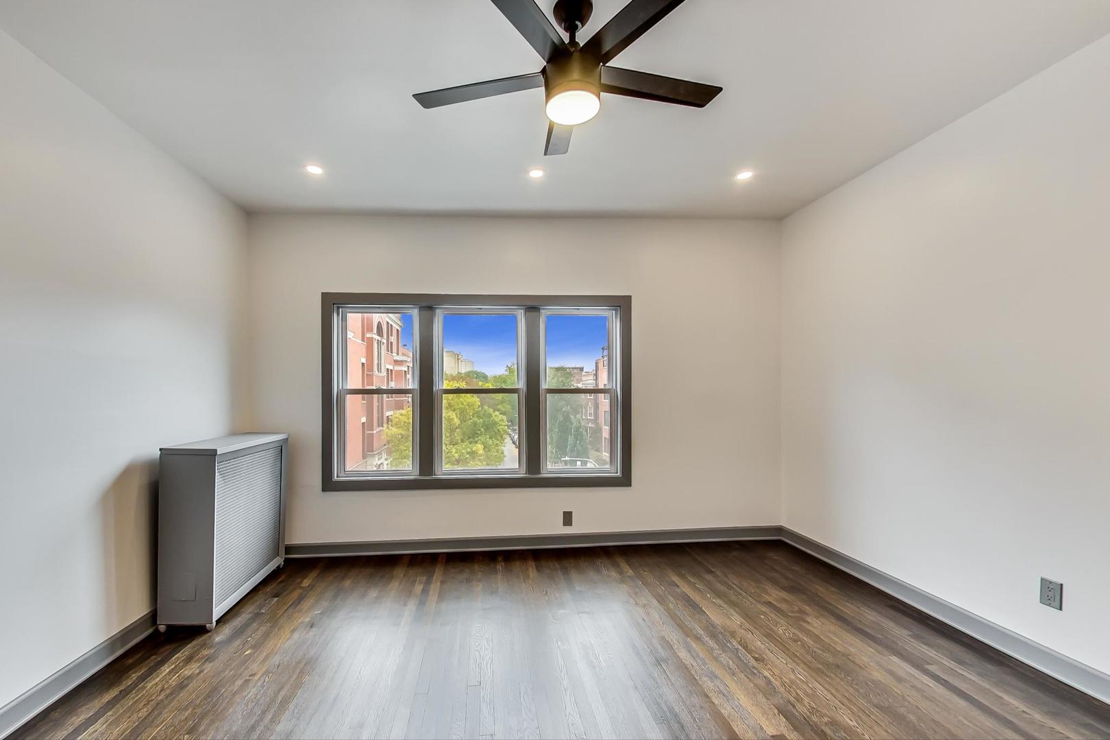 3263 North Broadway, Unit 3 Chicago, IL 60657 - Photo 14 of 37 a view of an empty room with a window and wooden floor