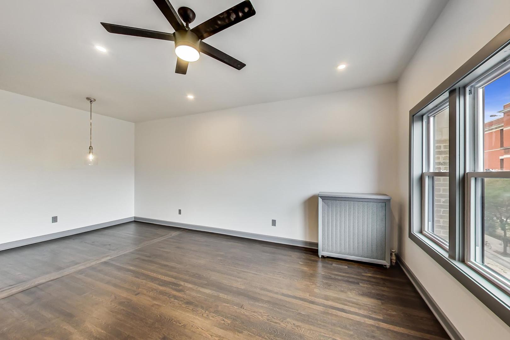 3263 North Broadway, Unit 3 Chicago, IL 60657 - Photo 15 of 37 an empty room with wooden floor and windows