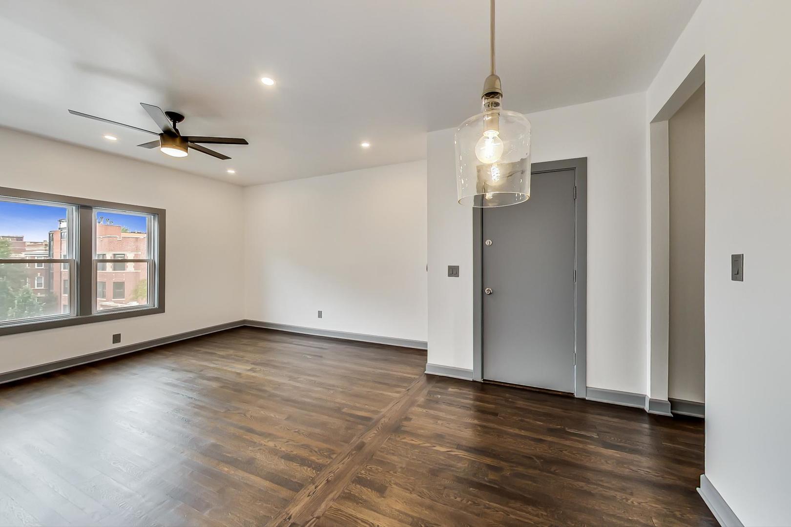 3263 North Broadway, Unit 3 Chicago, IL 60657 - Photo 18 of 37 a view of an empty room with wooden floor and a ceiling fan