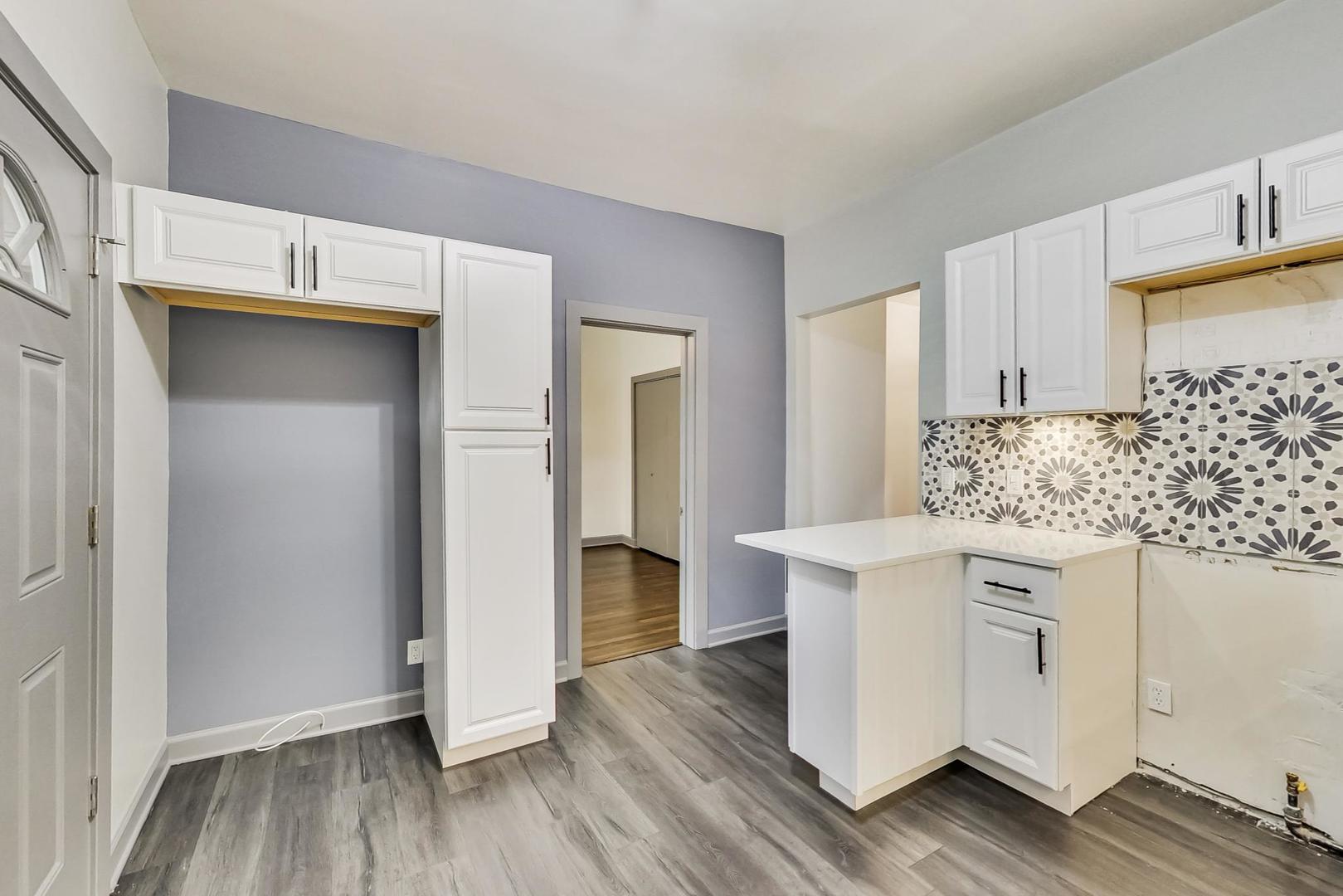 3263 North Broadway, Unit 3 Chicago, IL 60657 - Photo 22 of 37 a kitchen with stainless steel appliances a white stove top oven cabinets and wooden floor