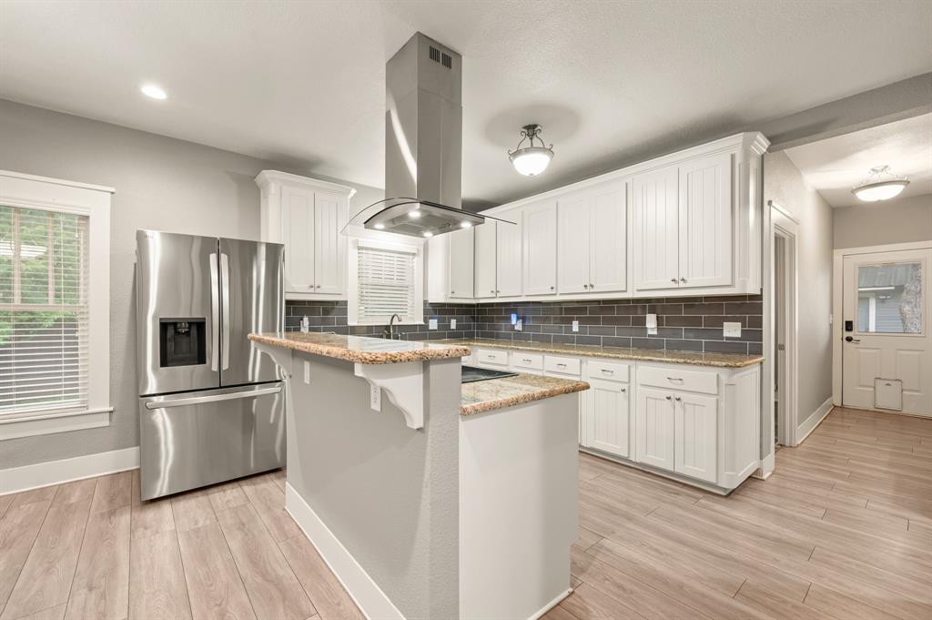 800 North Clements Street Gainesville, TX 76240 - Photo 10 of 27 a kitchen with white cabinets and stainless steel appliances