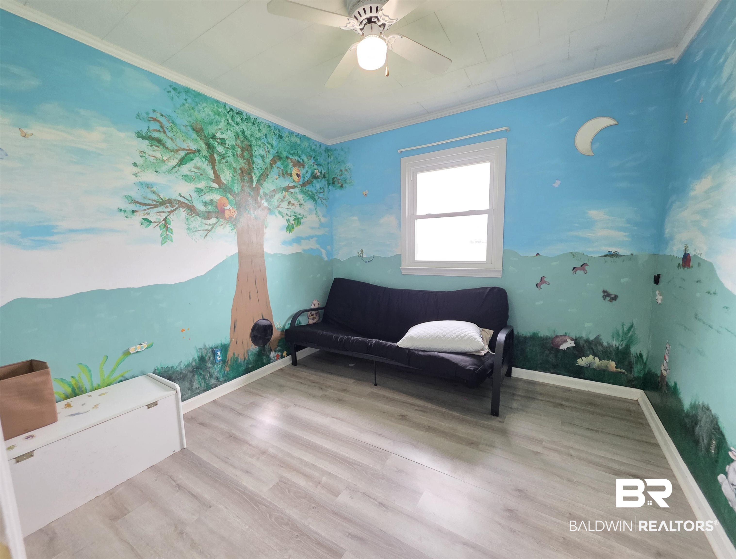 558 Stanton Road Atmore, AL 36502 - Photo 14 of 29 Interior room featuring light wood-finish flooring, a ceiling fan with integrated lighting, and a white window frame with a single pane
