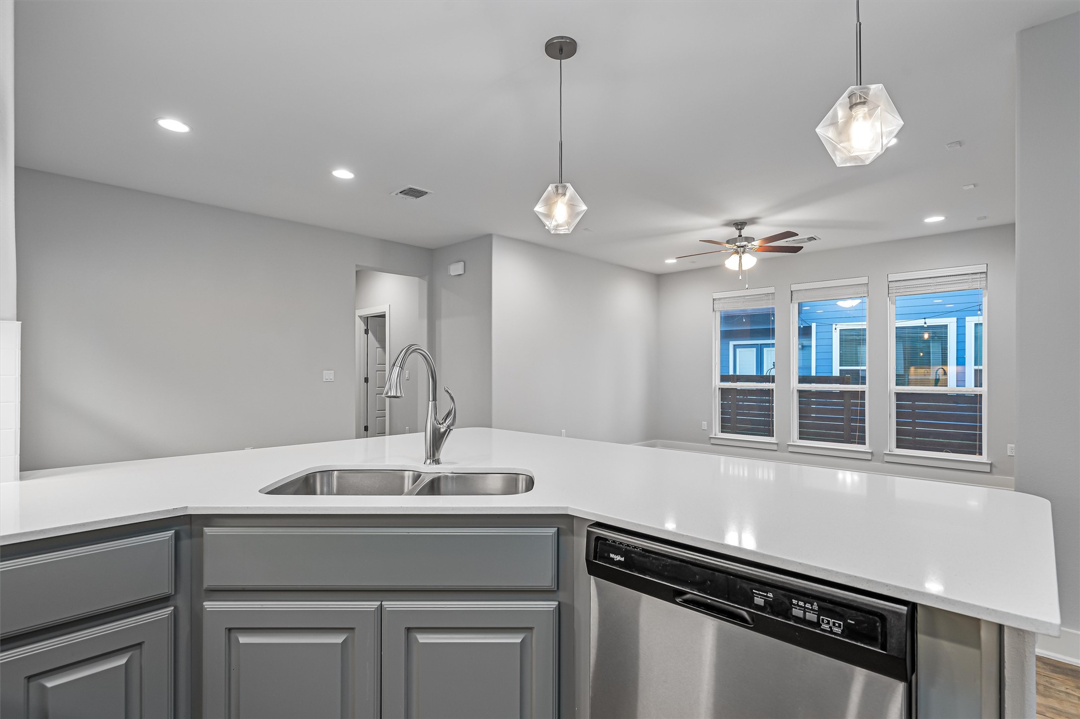 8709 Alderman Dr. Austin, TX 78747 - Photo 14 of 37 Kitchen with dishwasher, gray cabinetry, decorative light fixtures, light stone countertops, and ceiling fan