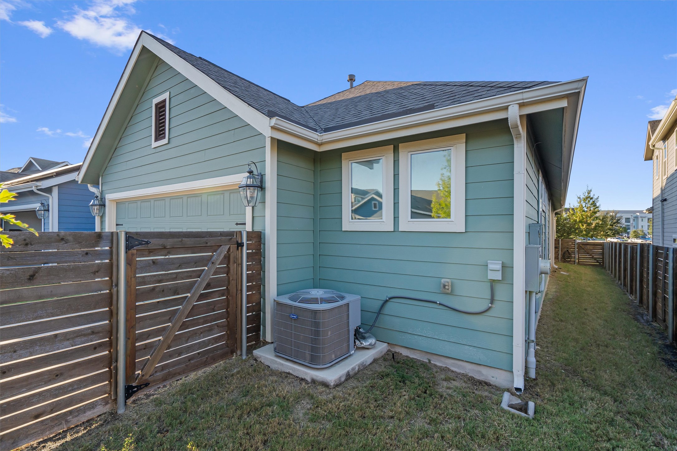 8709 Alderman Dr. Austin, TX 78747 - Photo 33 of 37 View of side of property with a fenced backyard, a shingled roof, and a gate