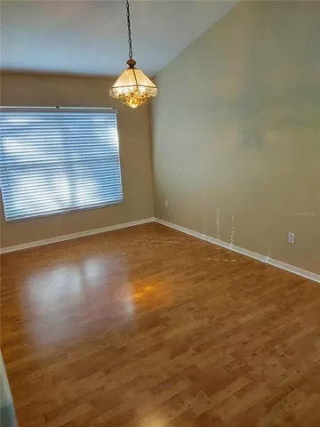 a view of a room with wooden floor and a ceiling fan