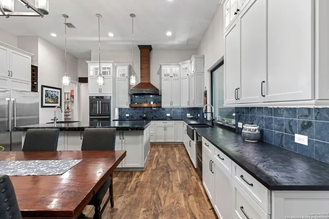 a kitchen with stainless steel appliances granite countertop a stove refrigerator and cabinets