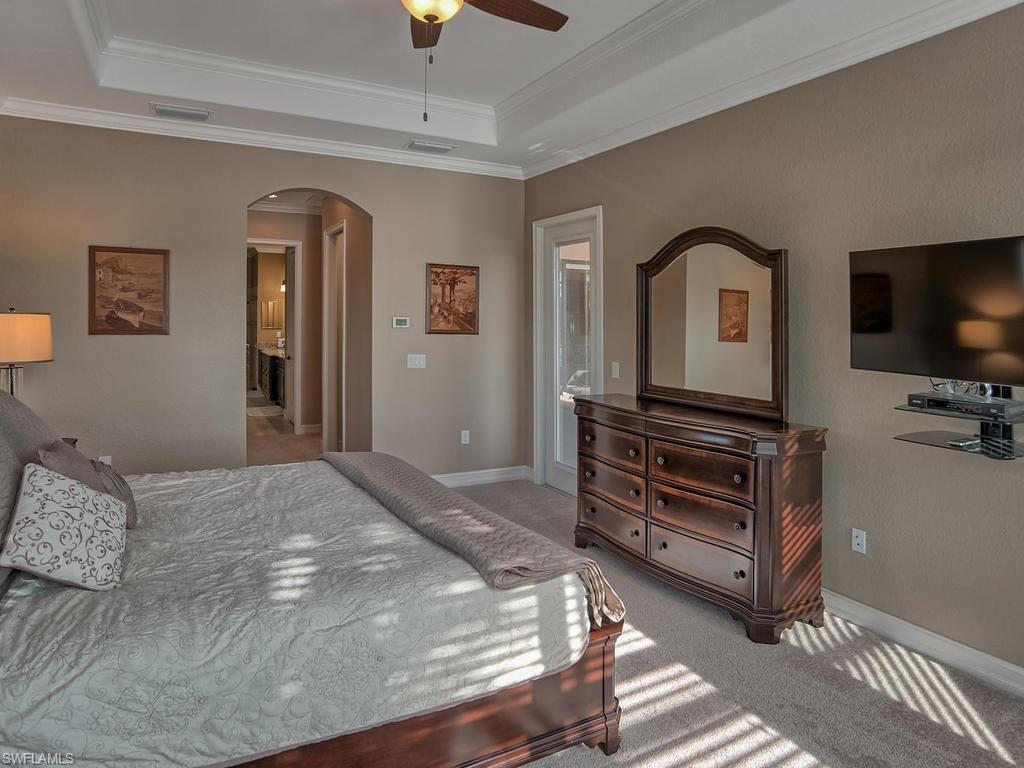 9634 Firenze Circle Naples, FL 34113 - Photo 12 of 35 a bedroom with a bed and flat screen tv