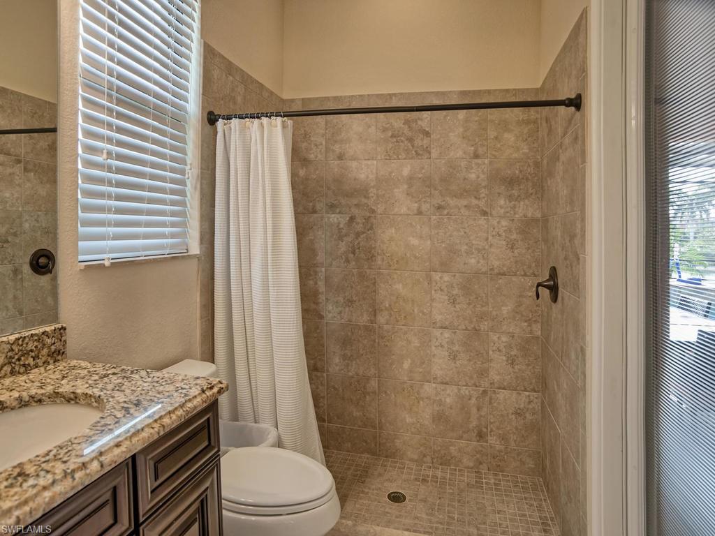 9634 Firenze Circle Naples, FL 34113 - Photo 18 of 35 a bathroom with a granite countertop sink toilet and shower