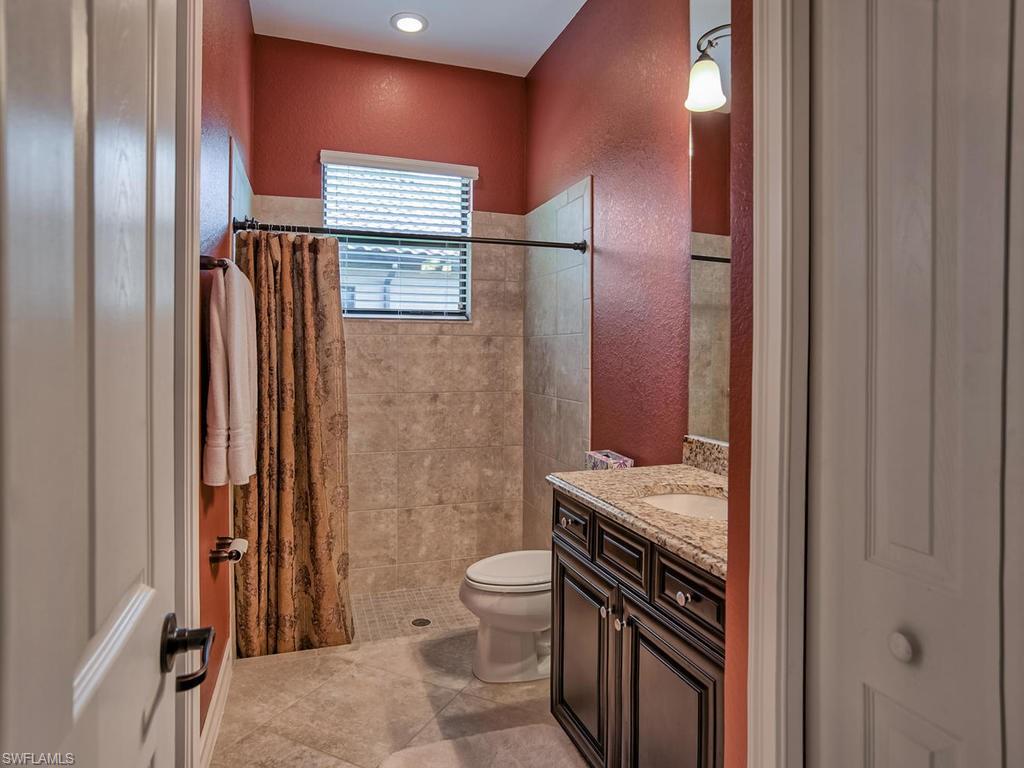9634 Firenze Circle Naples, FL 34113 - Photo 19 of 35 a bathroom with a granite countertop sink toilet and shower