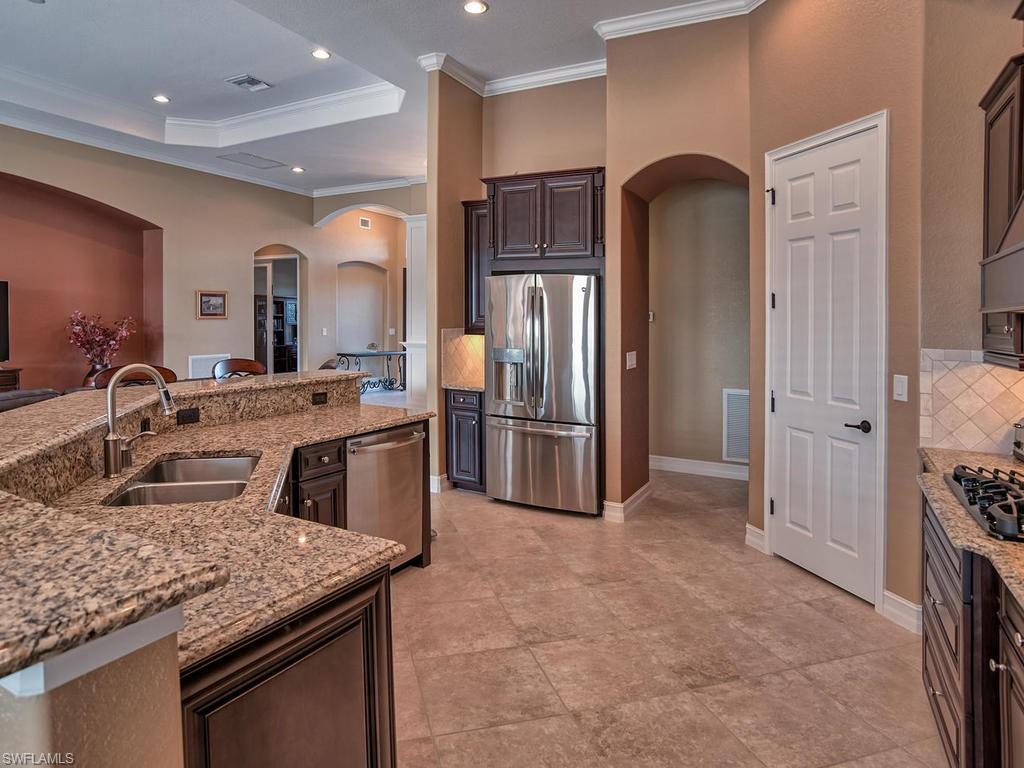 9634 Firenze Circle Naples, FL 34113 - Photo 7 of 35 a kitchen with stainless steel appliances granite countertop a sink and a refrigerator