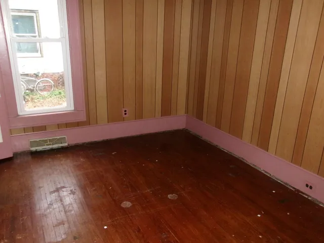 a view of a room with wooden floor and a window