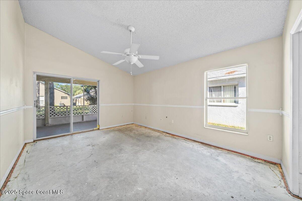 2798 Caitlin Court Melbourne, FL 32940 - Photo 10 of 27 an empty room with windows and chandelier