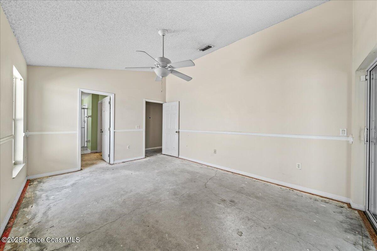 2798 Caitlin Court Melbourne, FL 32940 - Photo 11 of 27 an empty room with closet and a ceiling fan