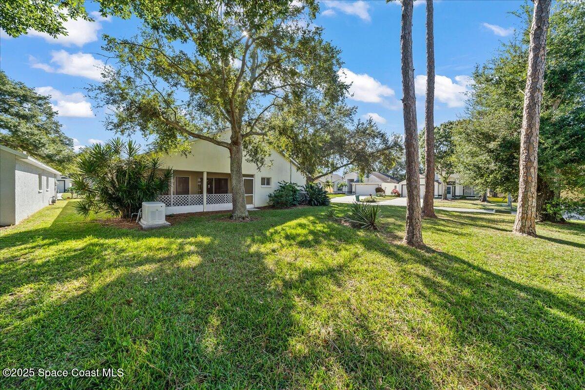 2798 Caitlin Court Melbourne, FL 32940 - Photo 24 of 27 a view of a house with a big yard and large tree