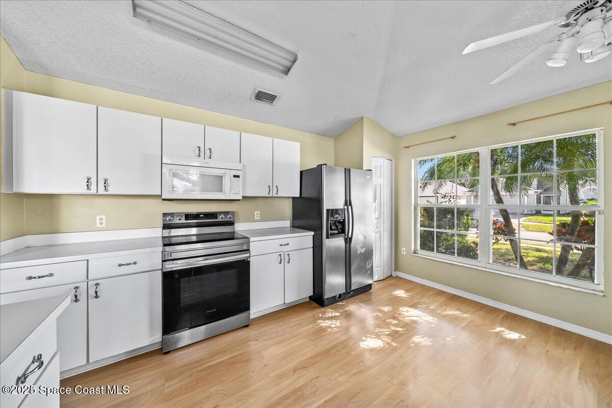2798 Caitlin Court Melbourne, FL 32940 - Photo 7 of 27 a kitchen with stainless steel appliances a stove cabinets and a refrigerator