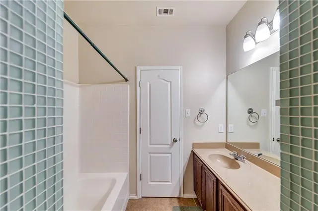 a bathroom with a granite countertop sink a toilet and shower