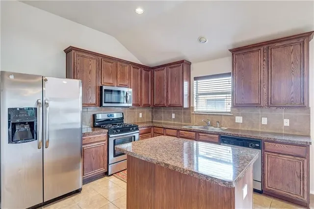 a kitchen with stainless steel appliances granite countertop a refrigerator stove a sink and dishwasher