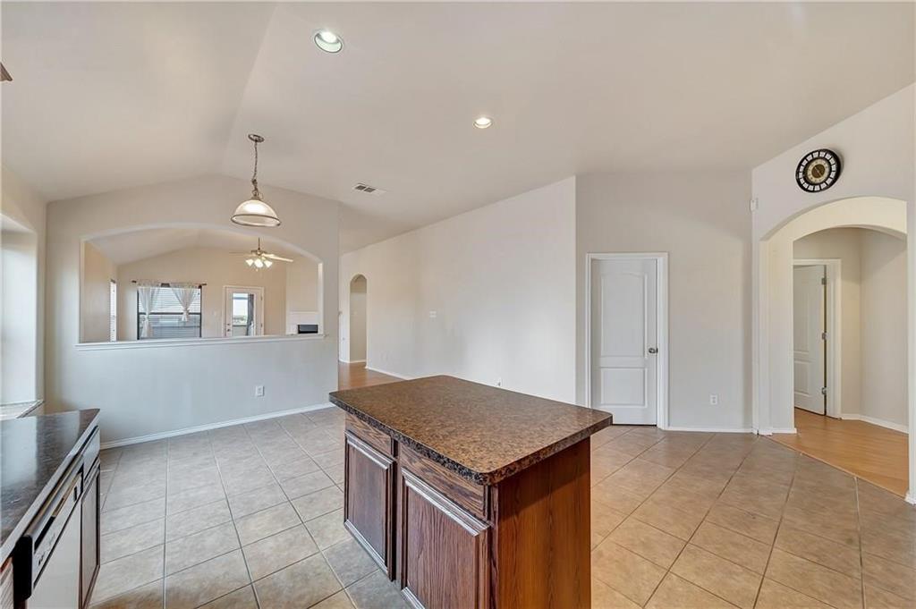 1404 Trading Post Drive Fort Worth, TX 76131 - Photo 9 of 25 a kitchen with kitchen island a sink a stove and a refrigerator with wooden floor