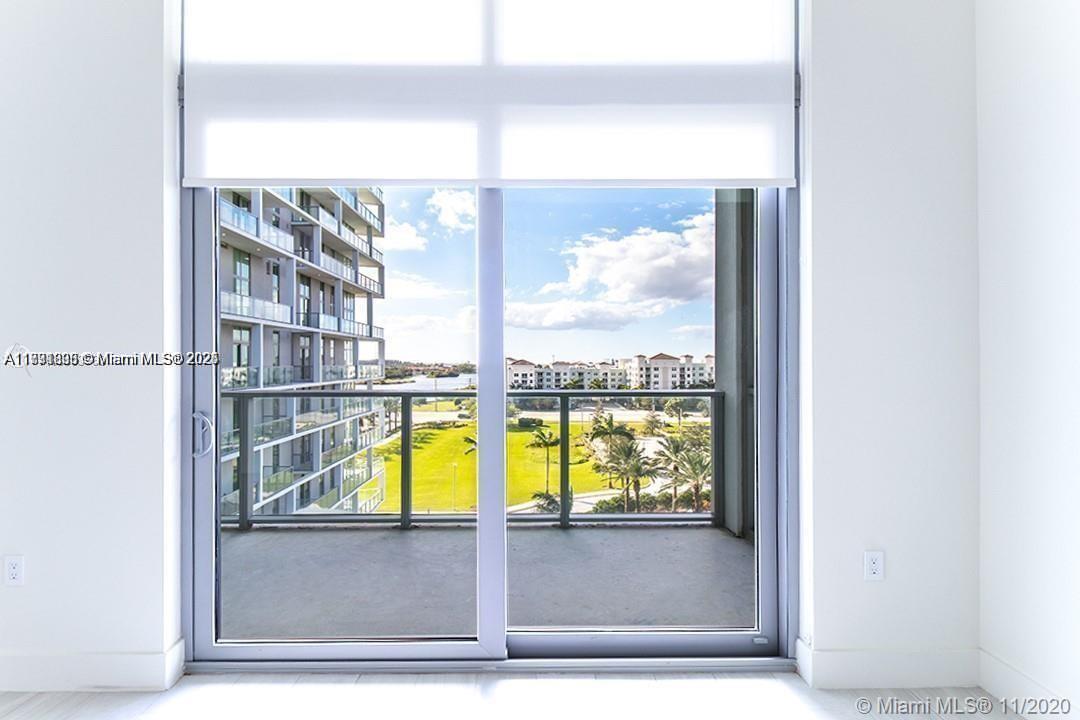 2000 Metropica Way, Unit 614 Sunrise, FL 33323 - Photo 6 of 18 a view of a living room with a floor to ceiling window and front door