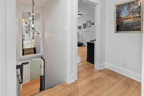 a view of a hallway with wooden floor and staircase