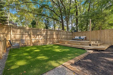 a view of a backyard with wooden fence and a bench