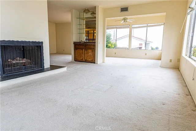 a view of an empty room with a fireplace and a window