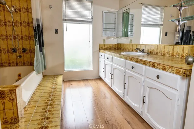 a bathroom with granite countertop double vanity and a bathtub